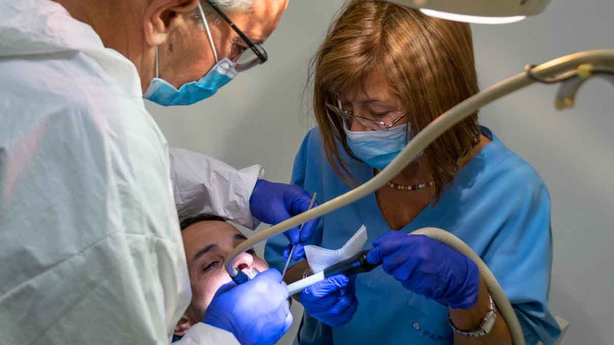 dentists placing dental implant