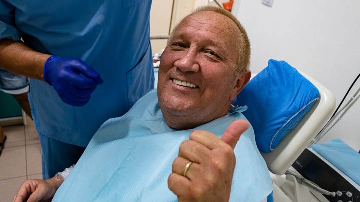 patient after dental implants with thumbs up